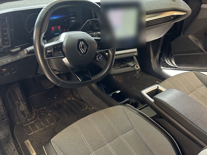 Poste de conduite d'une Renault Mégane E-Tech avant intervention, tapis de sol chargés de terre